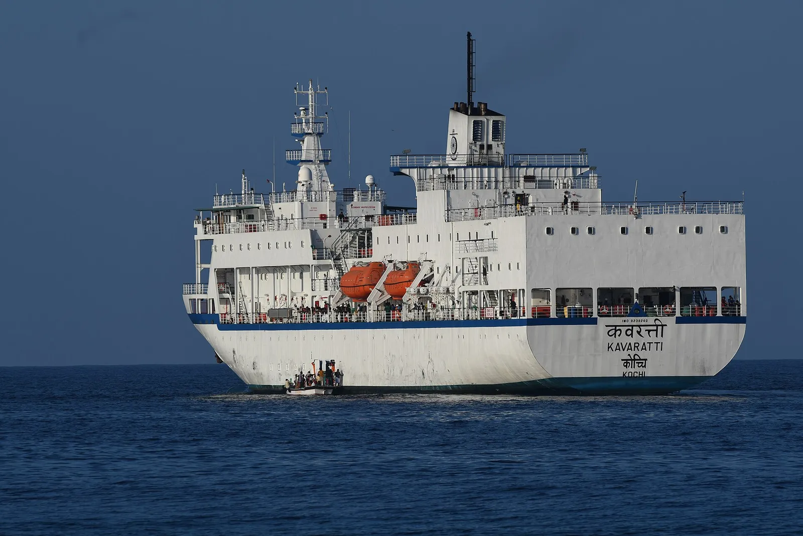 White passenger ship MV Kavaratti on deep blue sea, a small tender boat alongside its hull